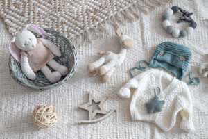 akcesoria dla niemowlaka – ubranka i zabawki dla noworodka na neutralnym tle