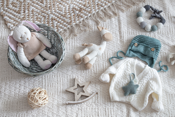 akcesoria dla niemowlaka – ubranka i zabawki dla noworodka na neutralnym tle